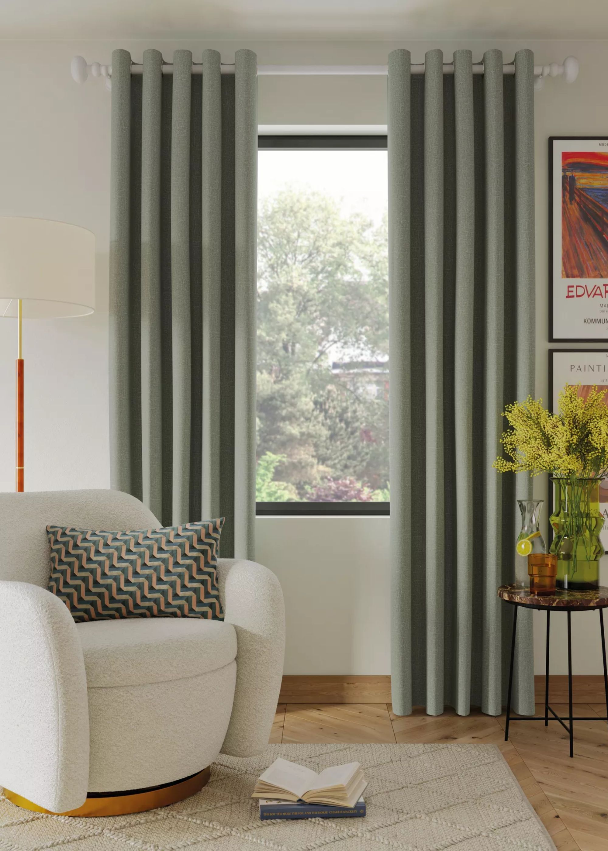Sage green curtains in a home next to a white/cream accent chair. A side table is placed next to the curtains with a large pot of flowers
