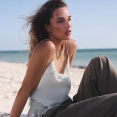 J.Crew model on beach wearing Relaxed Utility Pants in Cotton Blend and white tank top