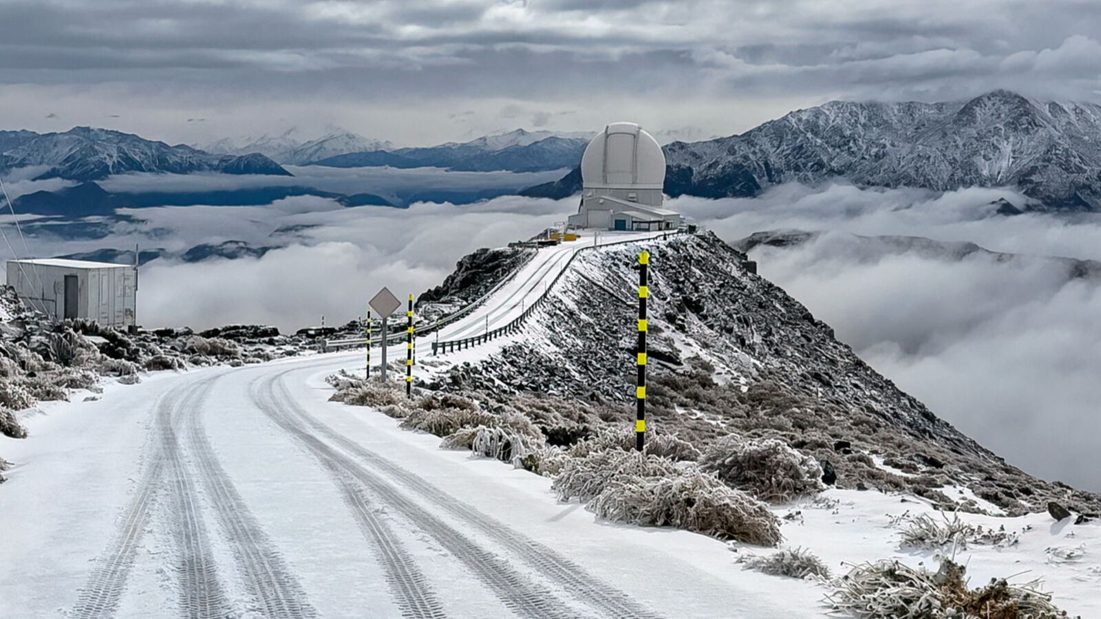 A telescope sits on a cliff covered in snow