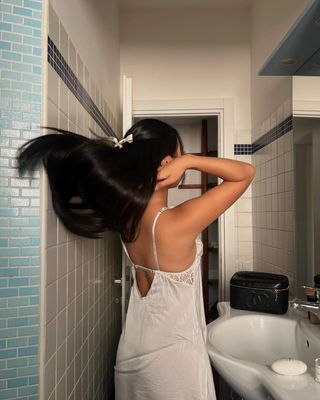 Woman flipping her long black hair over her shoulders.