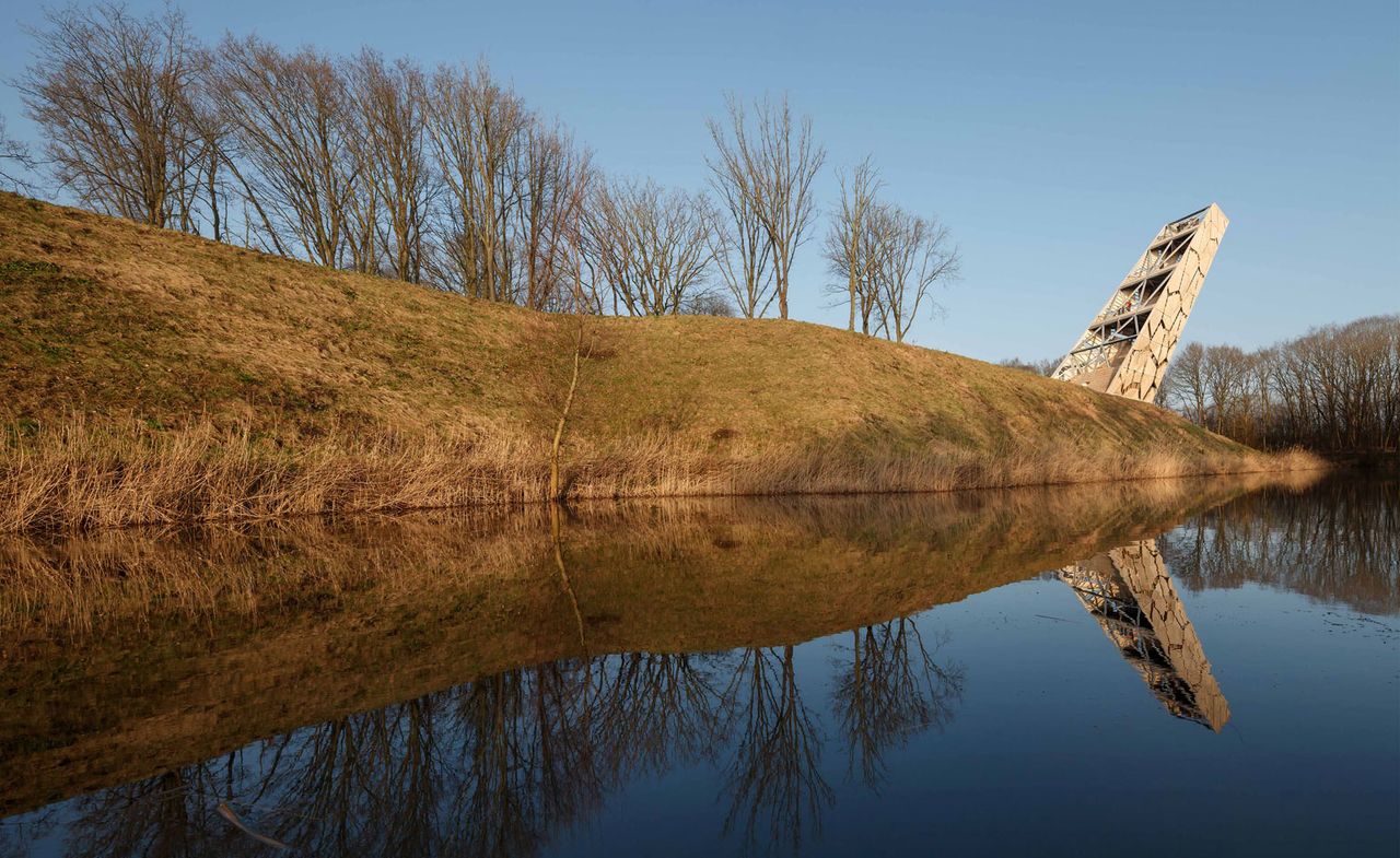 The Pompejus tower photographed from a distance with views of the trees, a lake and fields