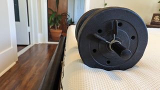 A 15lb dumbbell on the edge of the Essentia Stratami Organic mattress to test its edge support