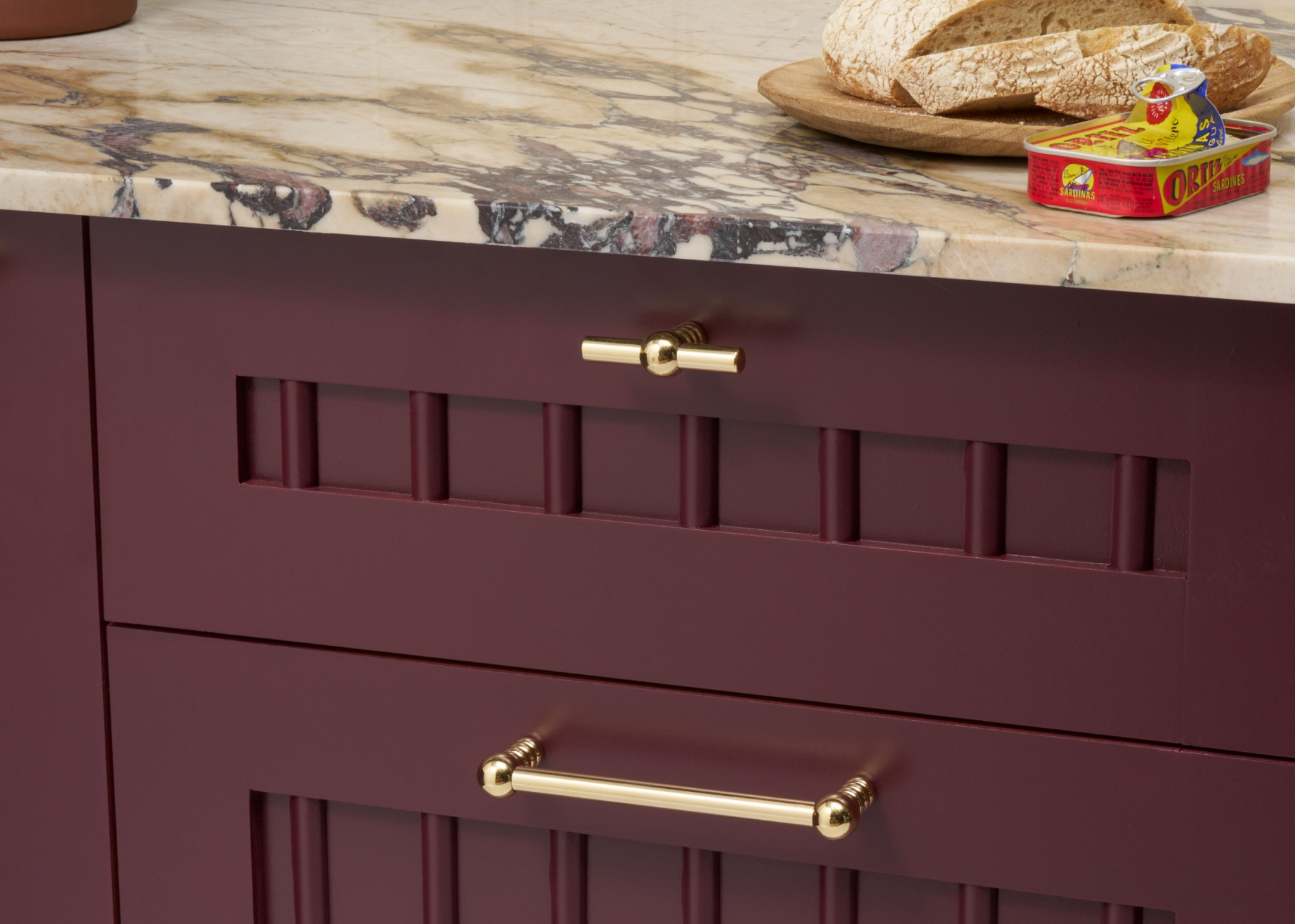 An aubergine kitchen with brass handles