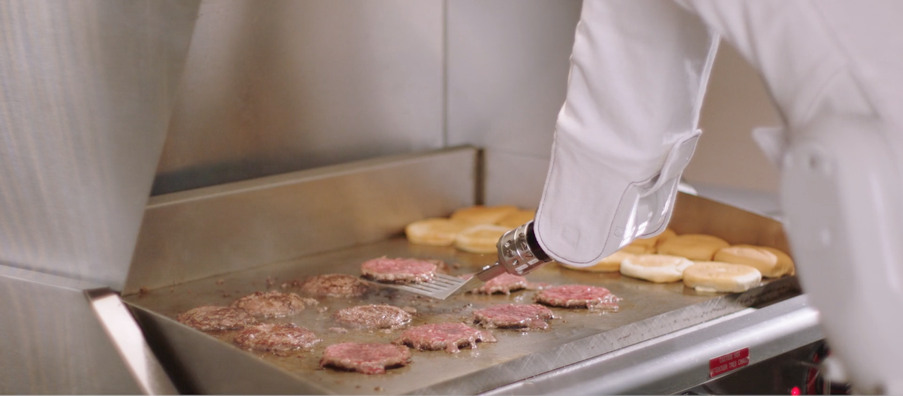 A robot flipping burgers.