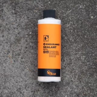 A bottle of Orange Seal Endurance Formula on a concrete background