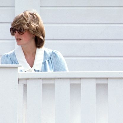 Queen Elizabeth II and Diana, Princess of Wales, wearing sunglasses and a pale green maternity dress with a white collar designed by Catherine Walker, while pregnant with Prince William, attend a polo match at Guards Polo Club on May 30, 1982 in Windsor, United Kingdom