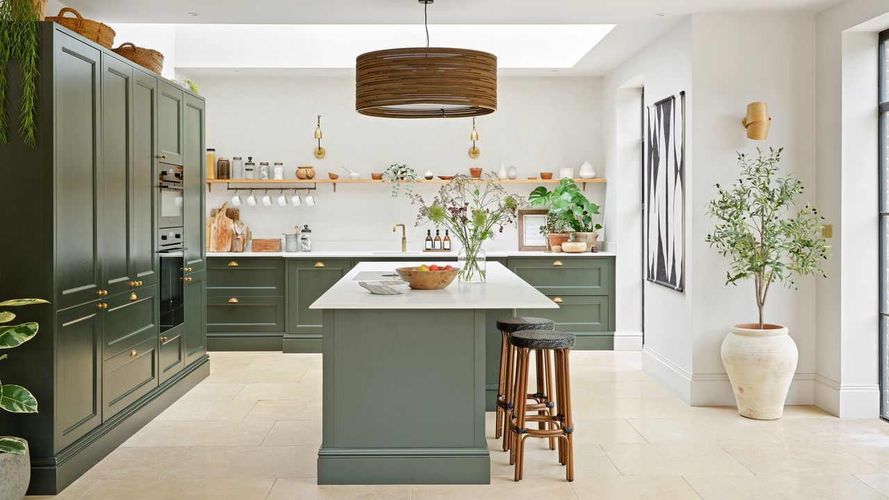 a dark green Shaker kitchen with brass fittings, kitchen island and pale walls Ideal Home&#039;s Best Home 2024