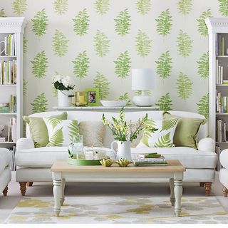 living room with fern printed wallpaper and white sofa