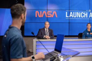 NASA Administrator Jim Bridenstine, sitting beneath a projection of the "worm" logotype, takes part in a SpaceX Demo-2 briefing at the Kennedy Space Center in Florida on May 26, 2020.