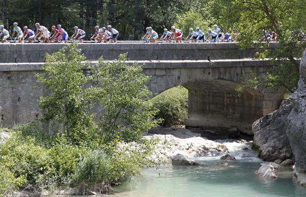 The bunch ride over a bridge on a warm stage 11 of the Tour de France