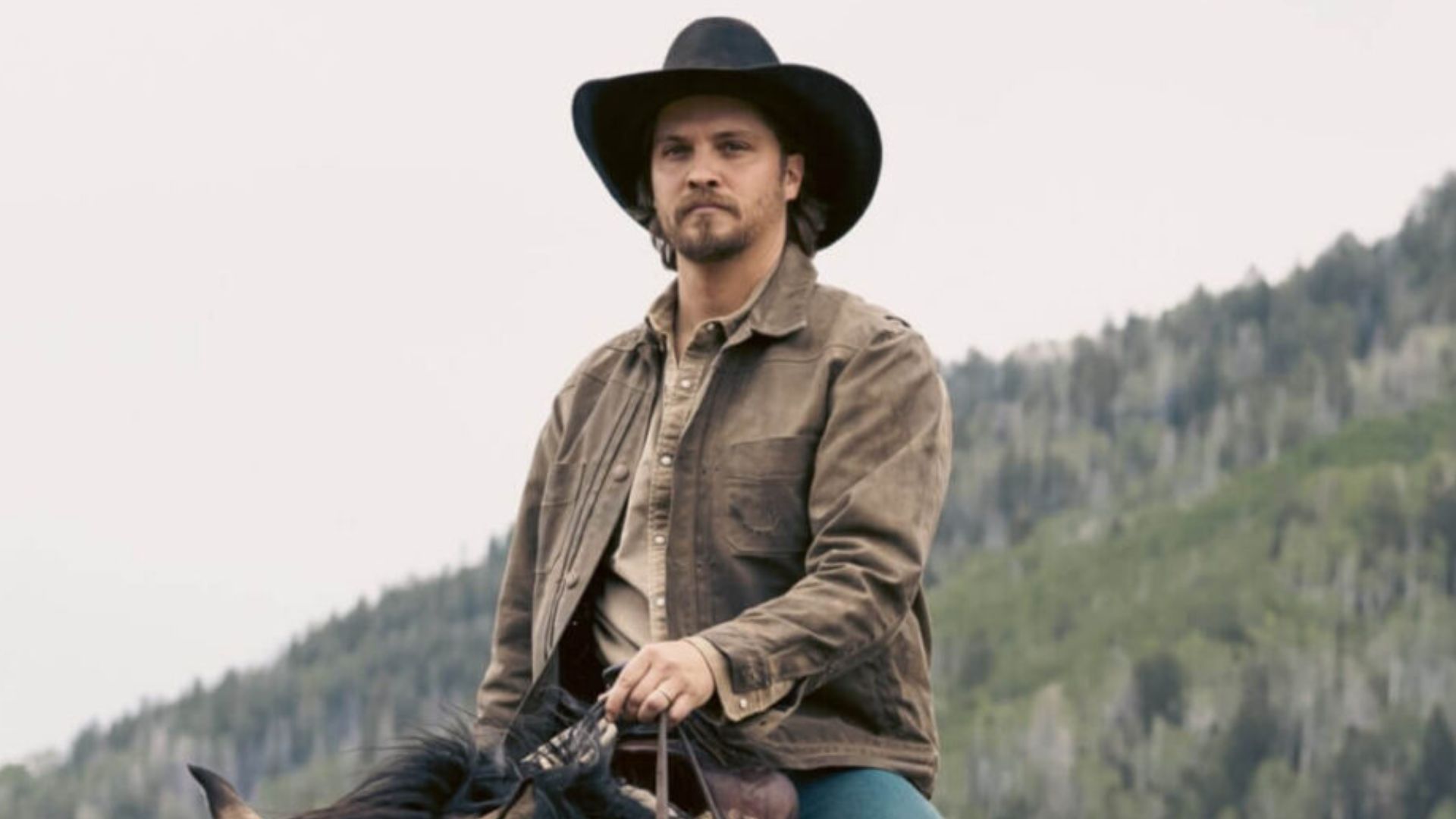 Luke Grimes sits on a horse