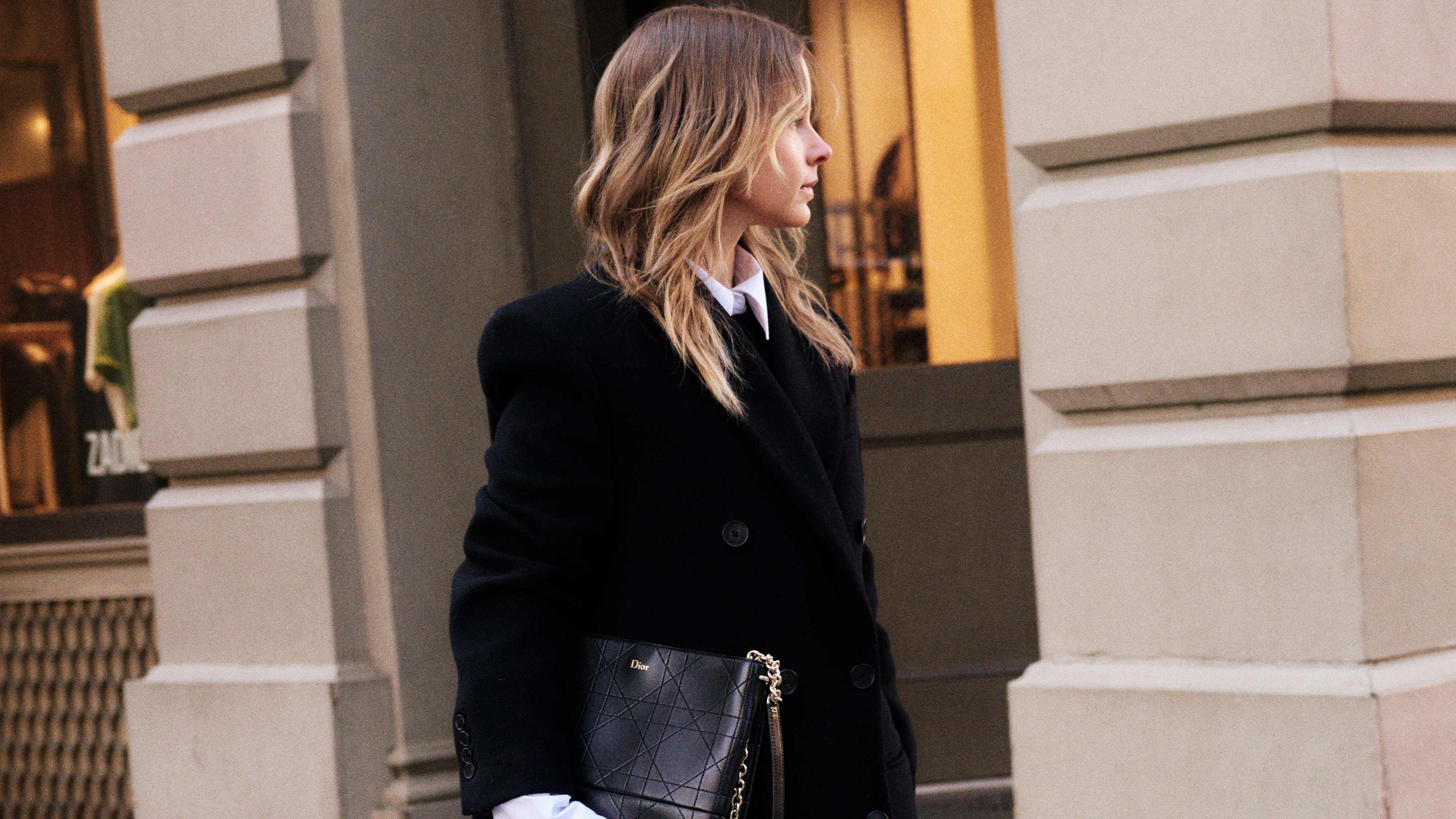 Nikki wears a black jacket and white button down with cashmere tights.