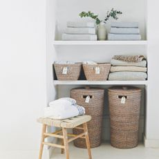 Shelves and baskets filled with towels and other laundry items