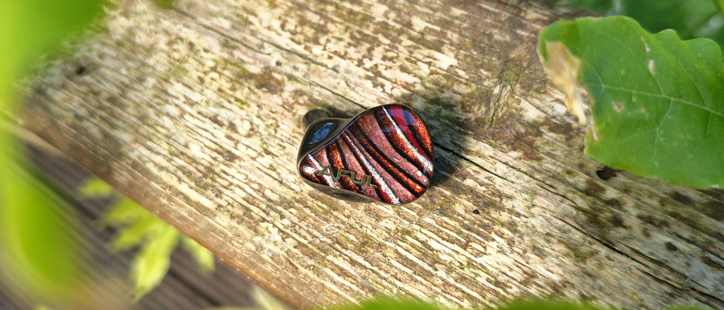 The Aful Performer 8s IEM on black and red pebbles. 