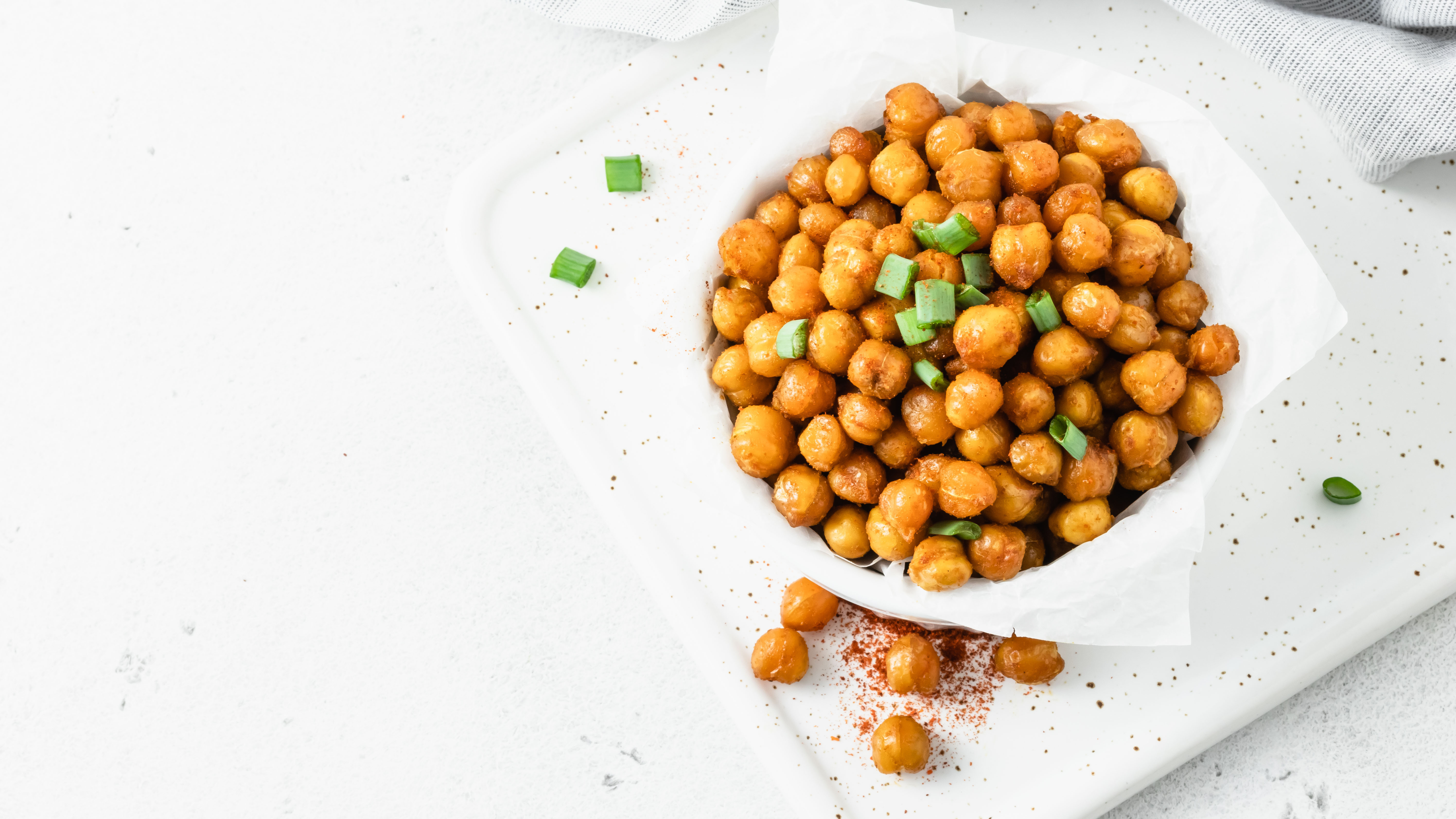 Looking down on a bowl of chickpeas on a white table