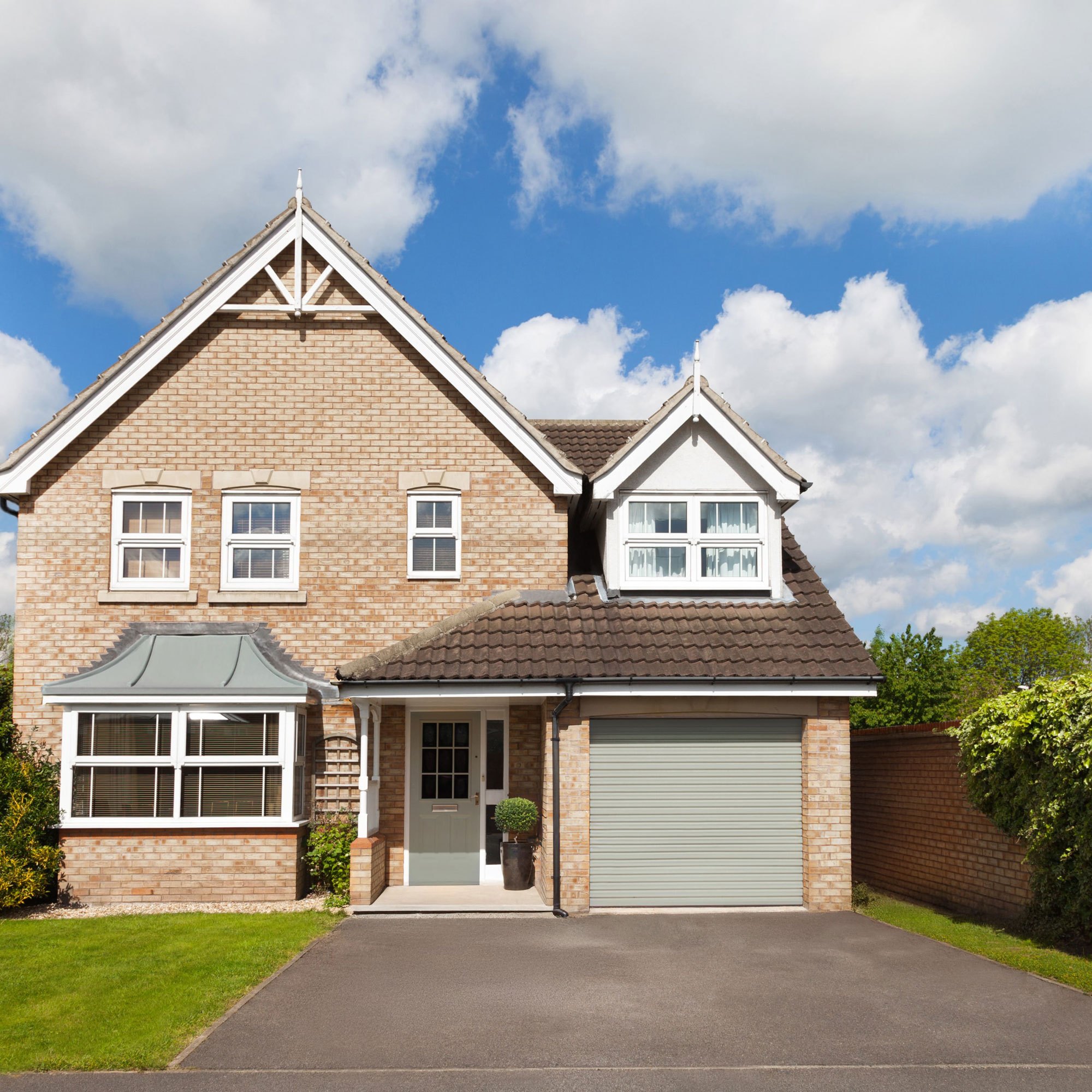 modern detached house with sloping tarmac driveway