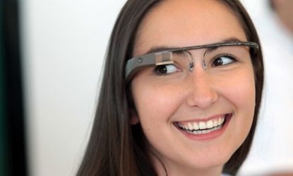 A Google employee wears a pair of Google Glass specs during the company's Developers Conference on June 27: The high-tech glasses are expected to hit the market in 2014.