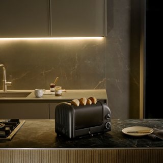 Stealth edition toaster on a black marble kitchen counter.