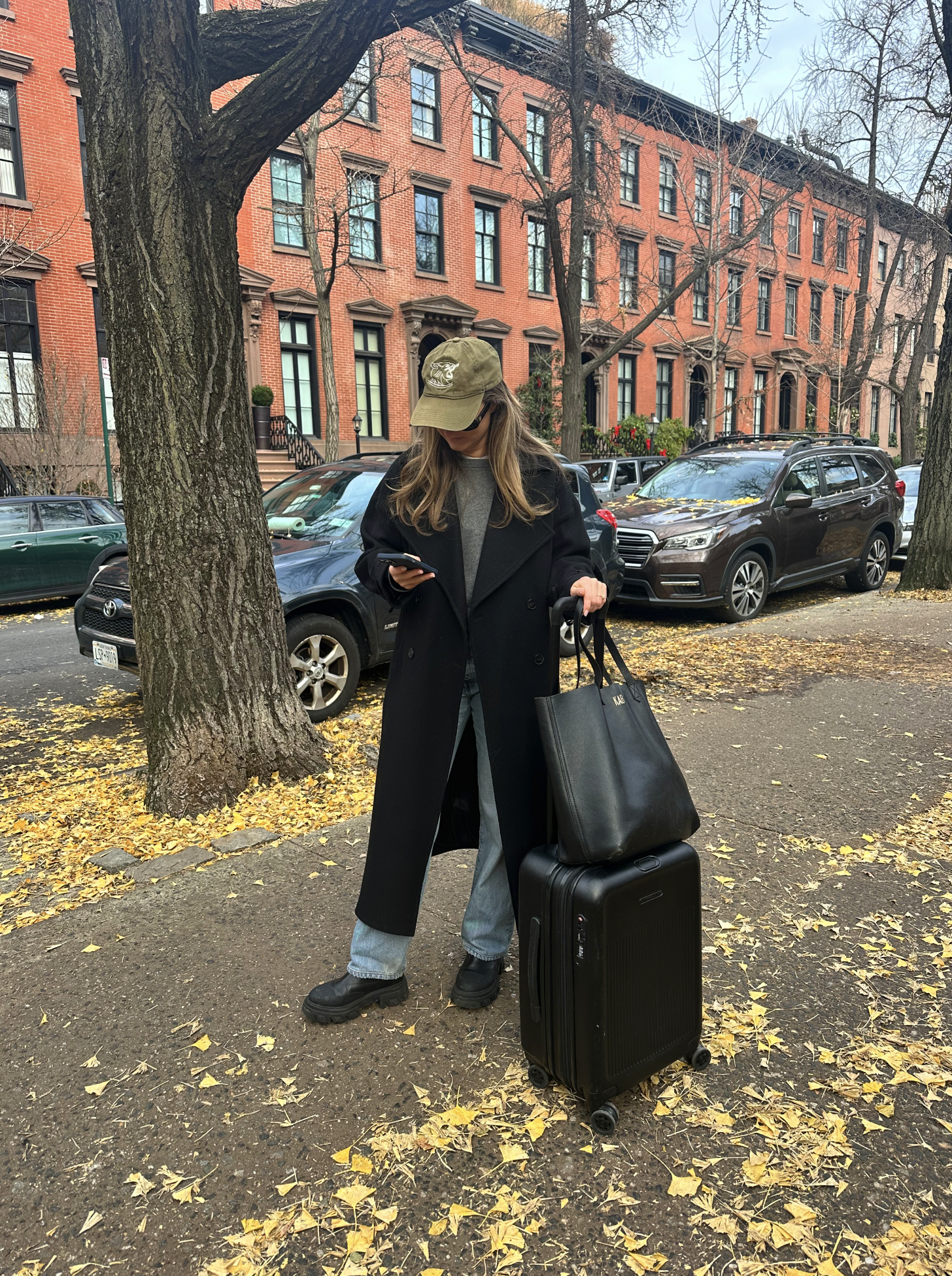 katie buckleitner crossing a fall street with a briggs and riley suitcase