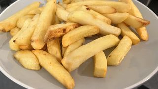 close up of cooked chips on a grey plate