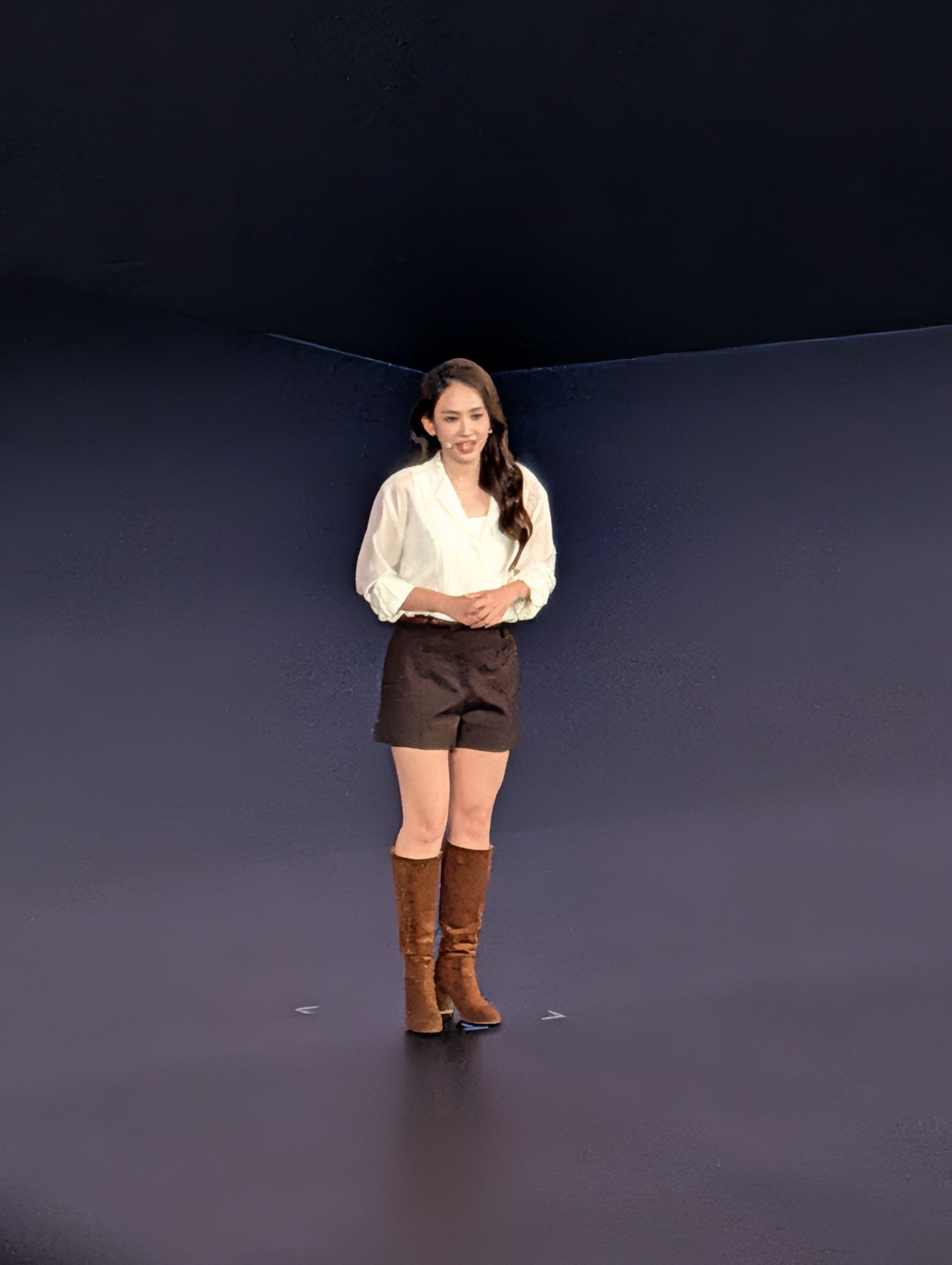 Woman standing on stage presenting