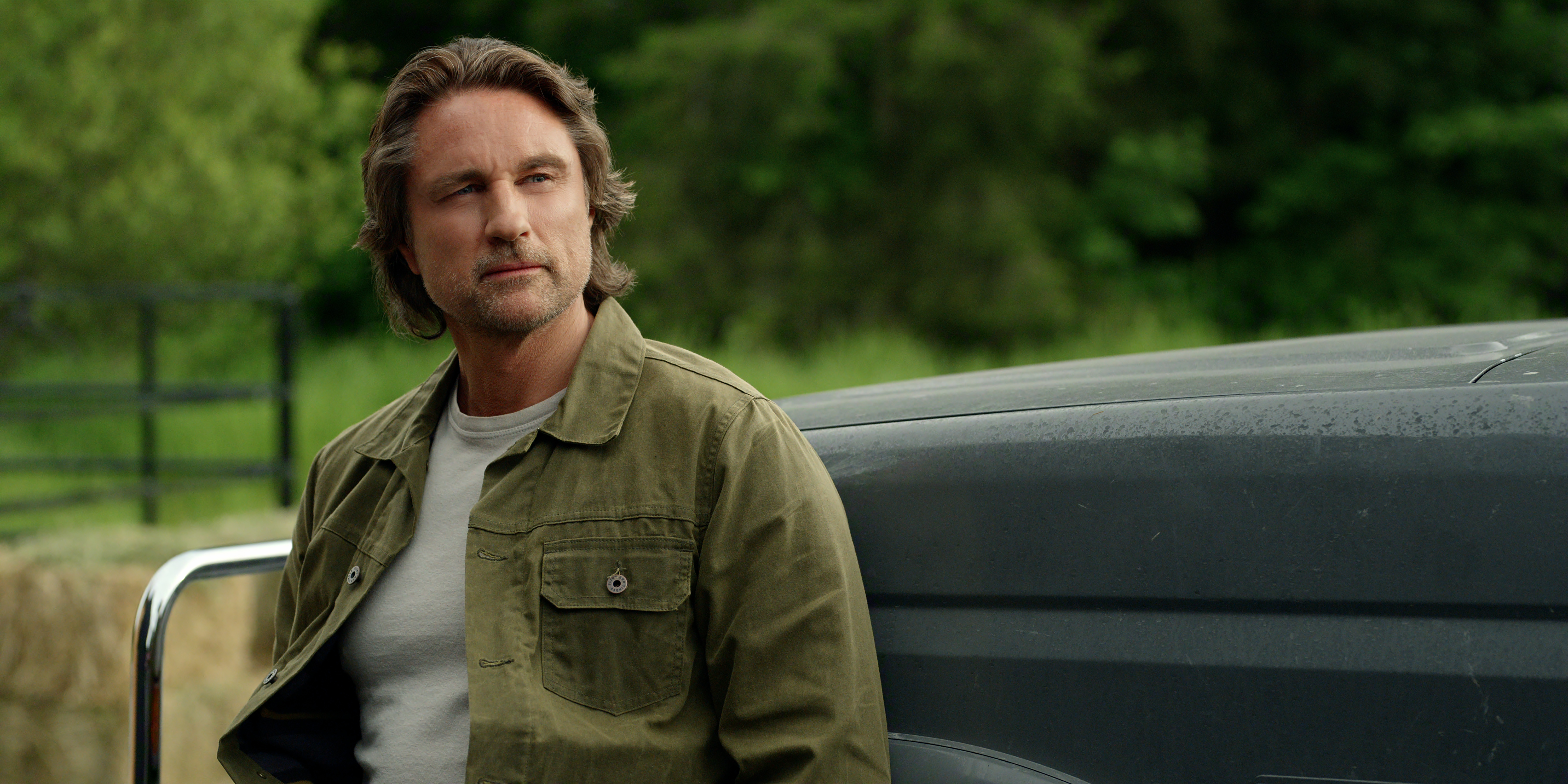 Martin Henderson as Jack Sheridan wearing a green shirt standing by a truck in virgin river season 7