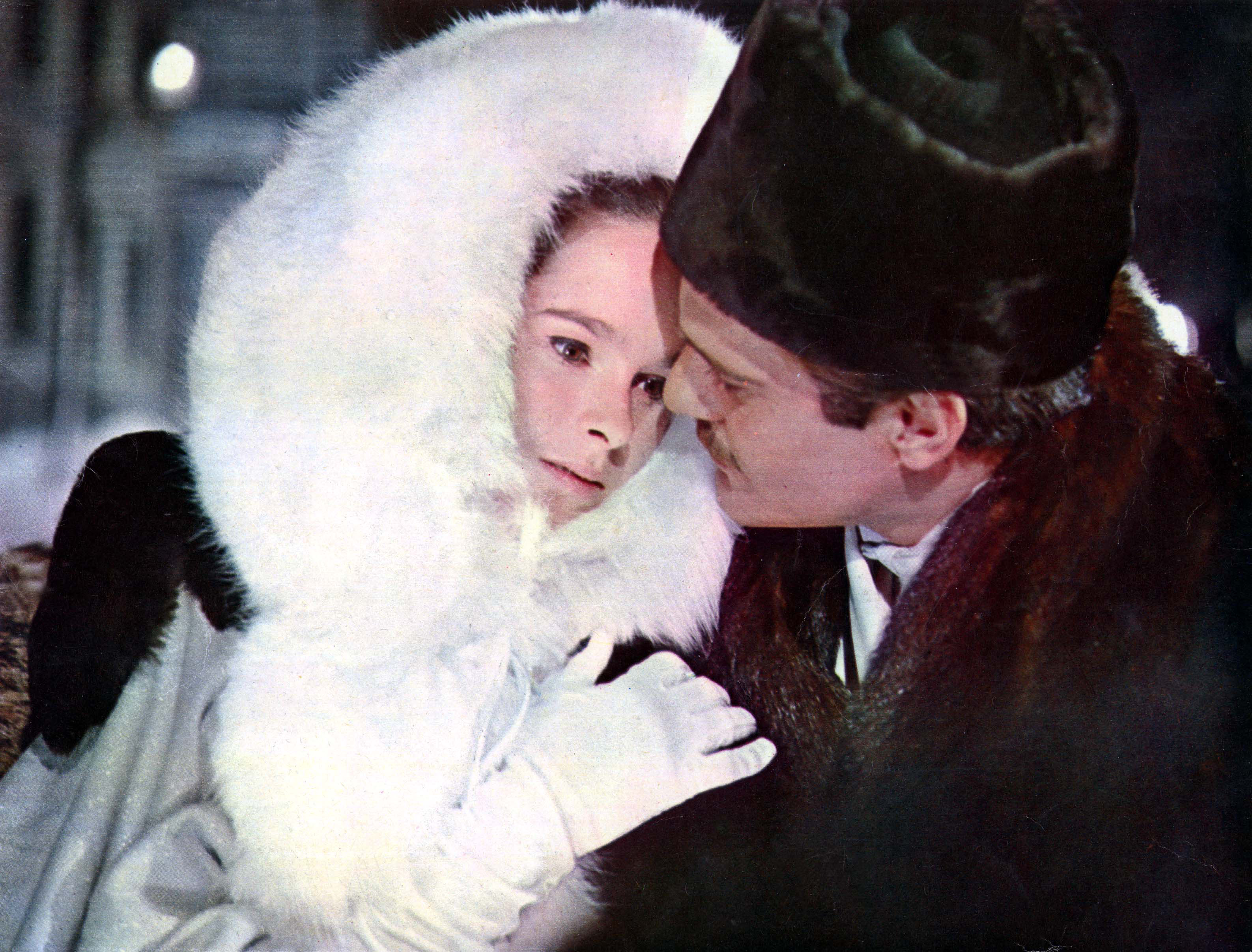 Woman and man embracing and wearing furs (hers white, his black). Still from Dr Zhivago.
