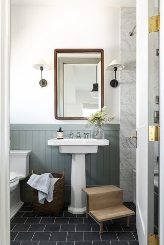 bathroom with slate gray floors, pigeon baseboard and pedestal sink