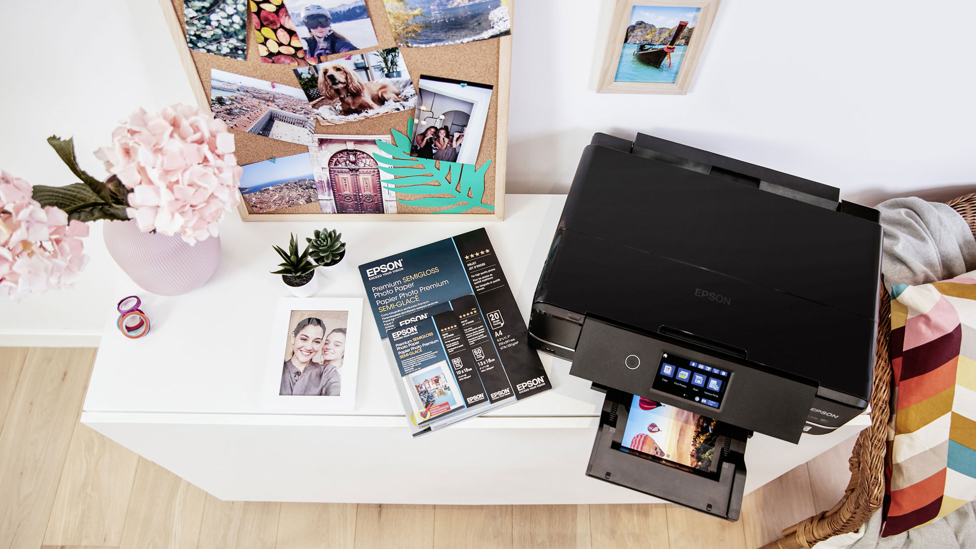 An Epson printer on a cabinet with spare paper and prints around it