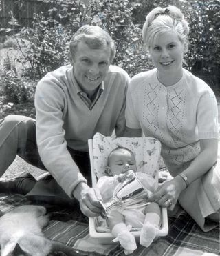 Footballer Bobby Moore With Wife Tina Moore And Their Baby Roberta Who Is Holding A Replica Of The European Cup Winners Cup Trophy Which West Ham Won That Year.