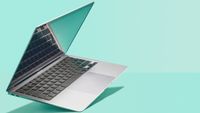 An Apple MacBook Air on a mint green background