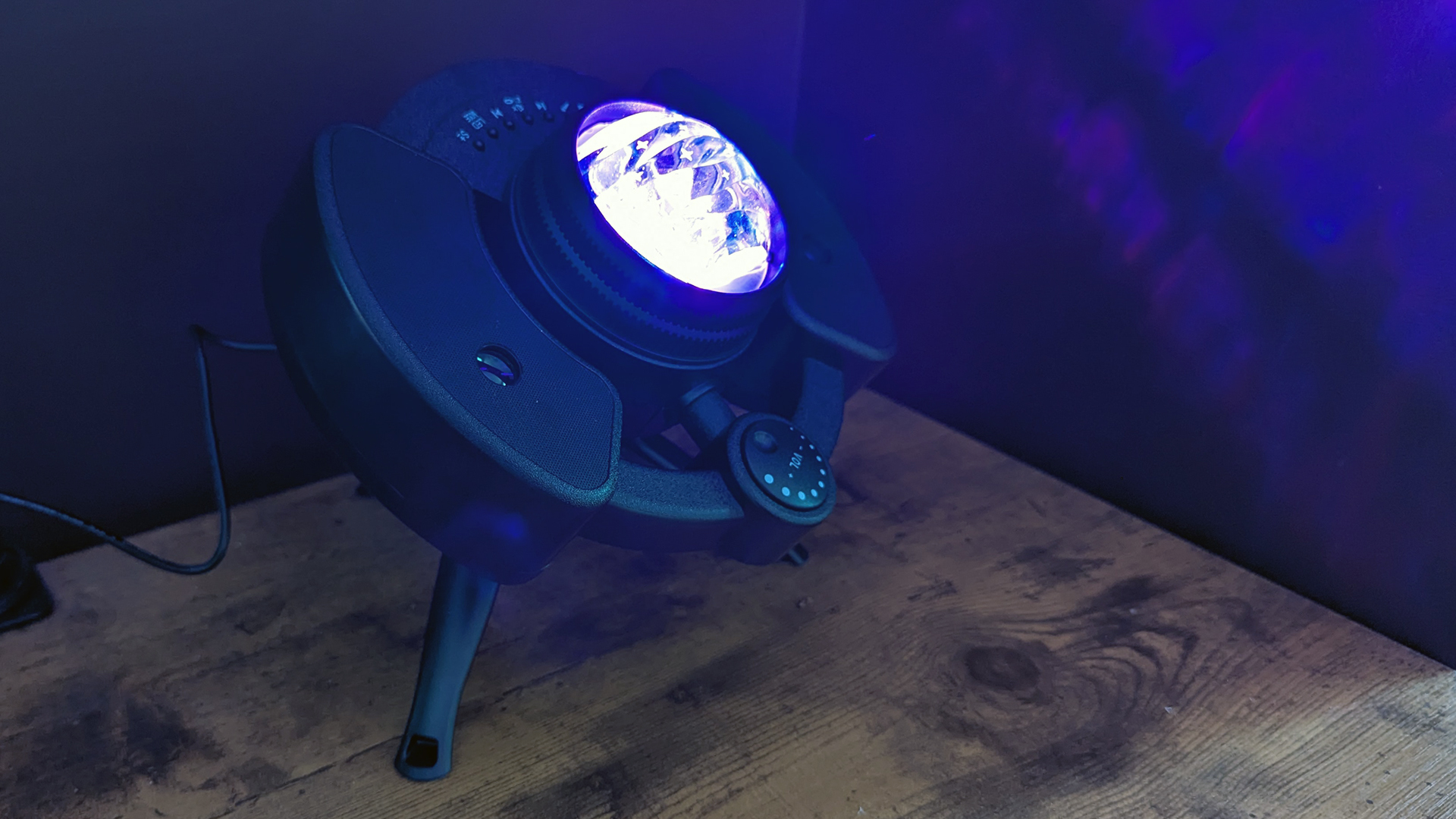 YgiTK Northern Galaxy Lights Projector during Review, on a wooden table against a dark coloured wall