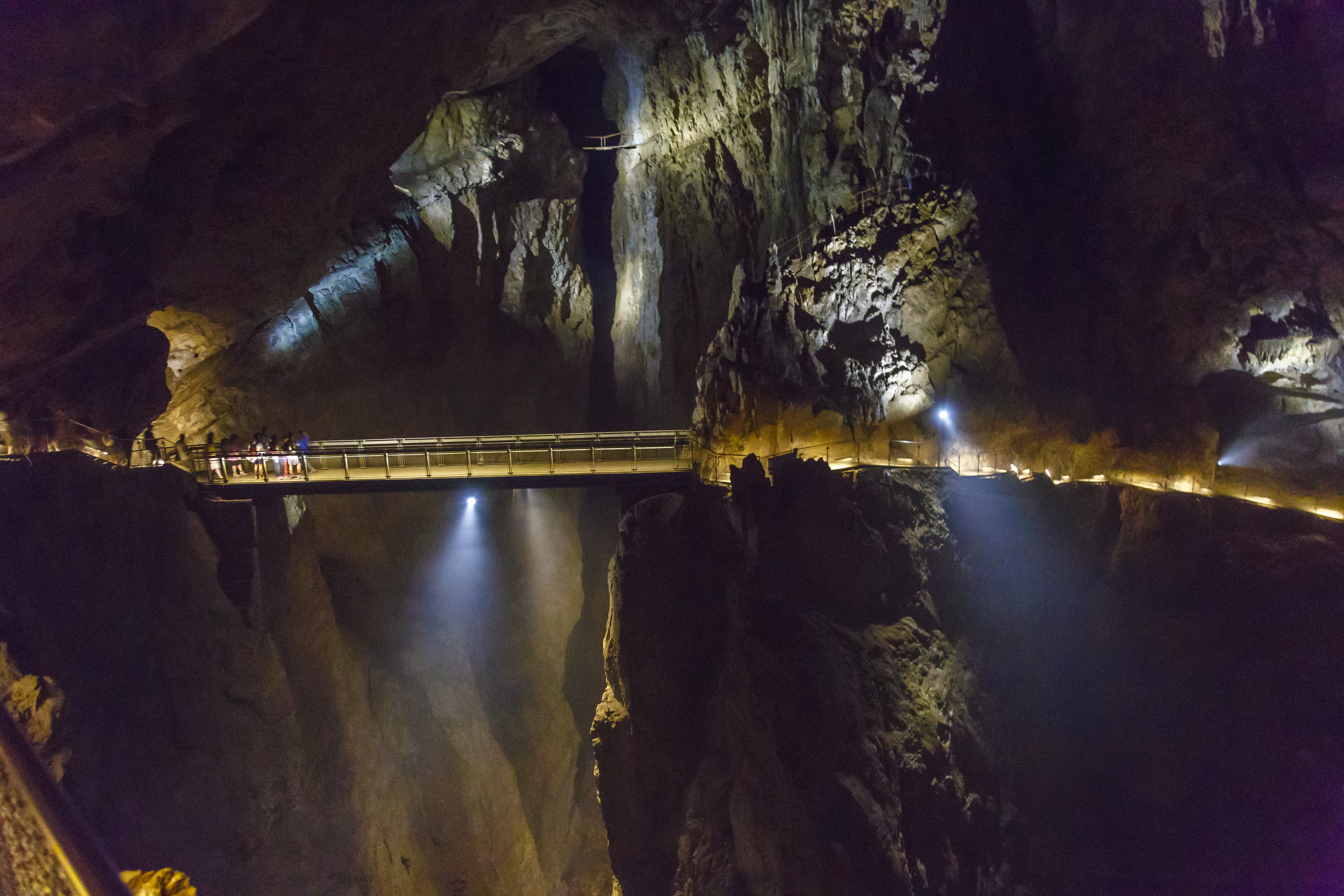 People walk across a walkway inside the Skocjan Caves in Slovenia