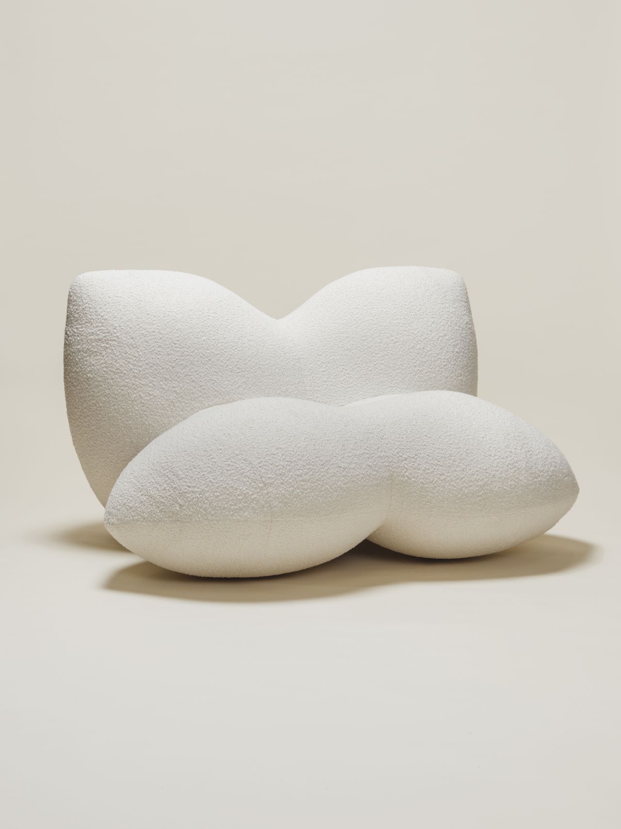 Chunky-looking furniture items including armchairs, chairs, stools, coffee tables, and sofas boast an organic feel and pleasing surface against a cream background.