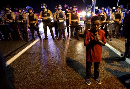 Amarion Allen, 11-years-old, stands in front of a police line during protests in Ferguson, Missouri, in 2015.
