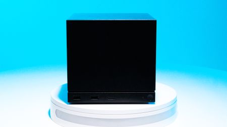 The Steam Machine on a white stand with a blue background and various ports on display.
