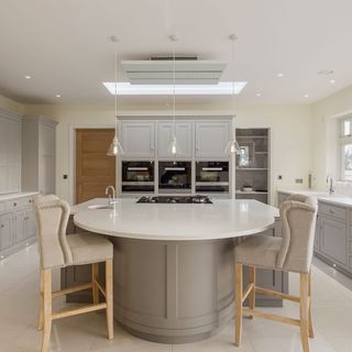 kitchen with hanging lamp lights and marble worktop with accent chair