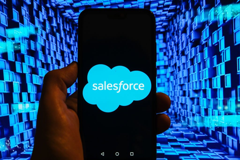 The Salesforce logo displayed on a smartphone in front of an abstract image of blue boxes