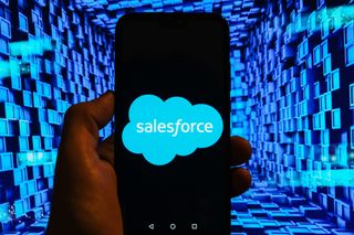 The Salesforce logo displayed on a smartphone in front of an abstract image of blue boxes