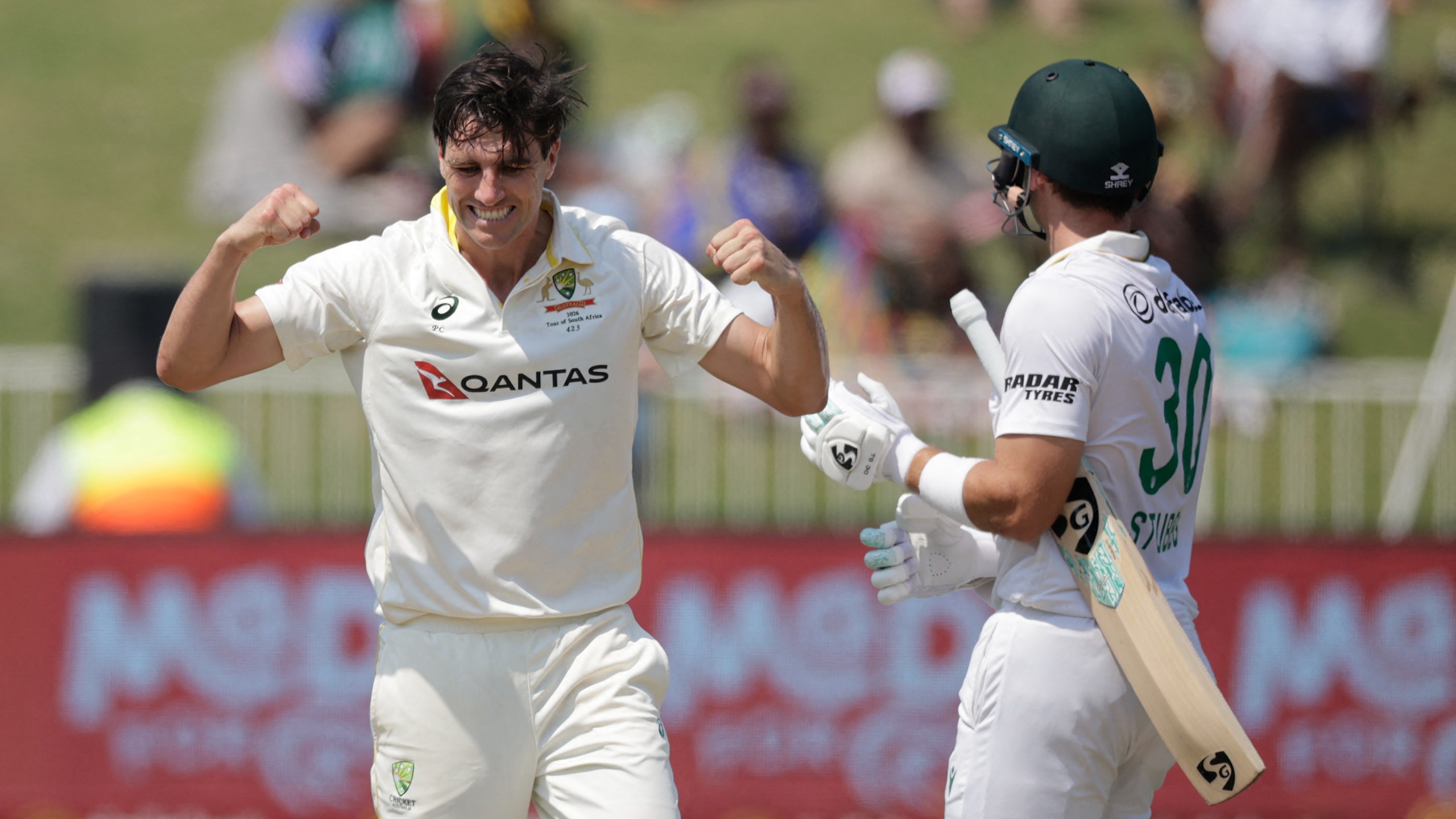 South Africa's Tristan Stubbs (R) walks back to the pavilion as Australia's Pat Cummins (L) celebrates his dismissal on day three of the first Test match between South Africa and Australia