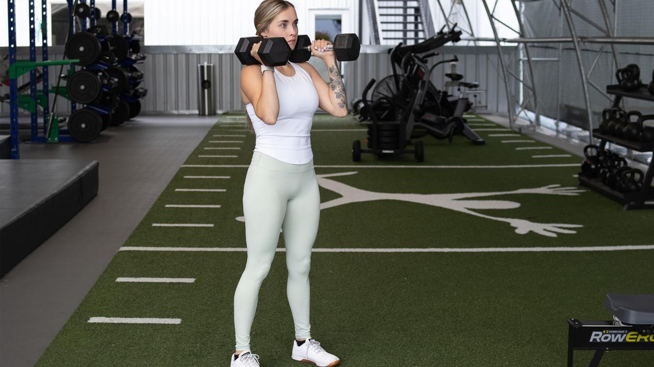 woman stands with dumbells