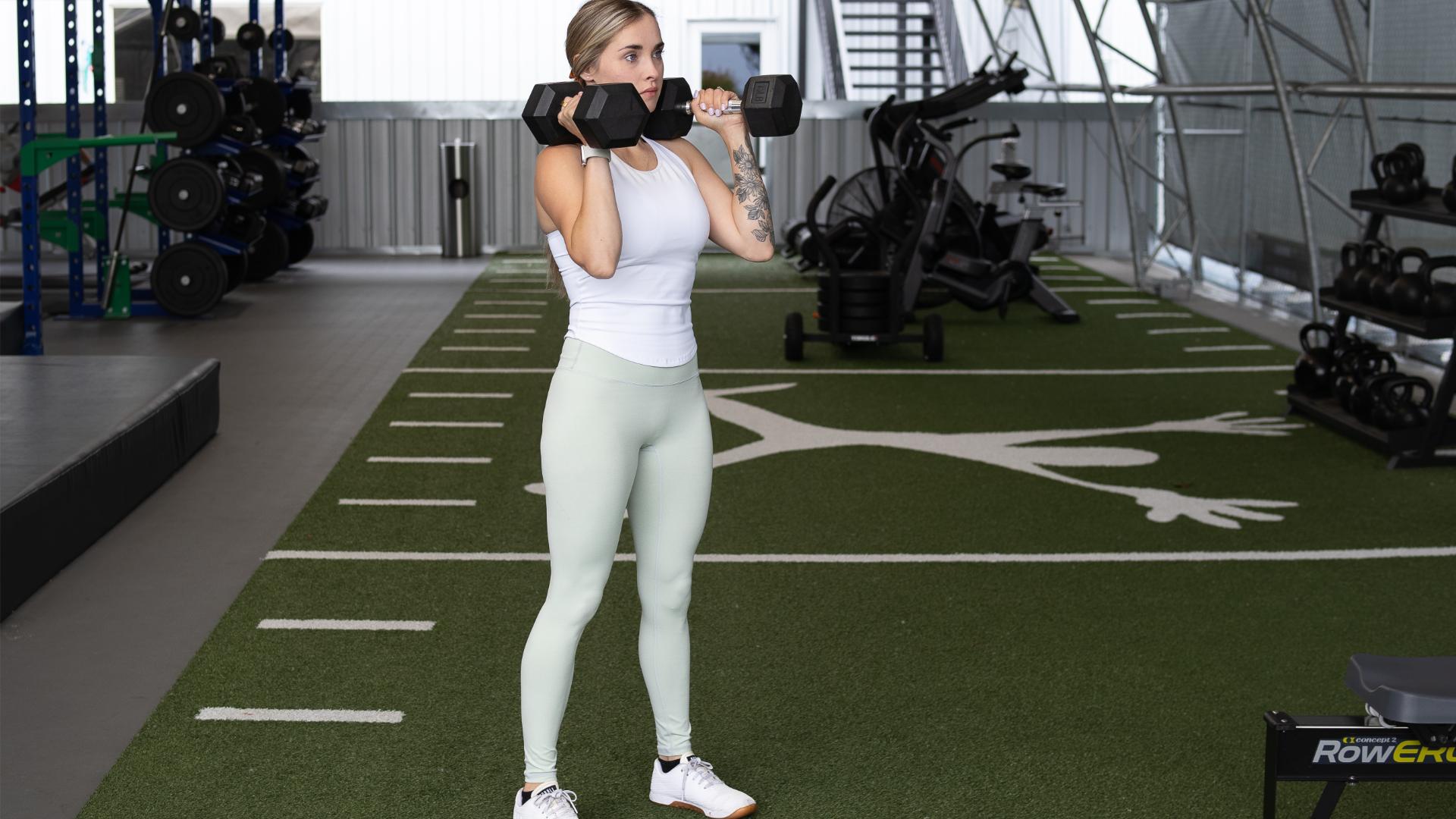 woman stands with dumbells