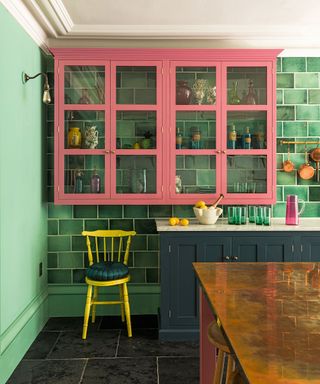 Pink and navy kitchen with green tiles and walls by DeVOL