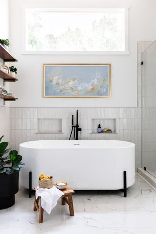 White bathroom with zellige tiles and freestanding bathtub with black hardware