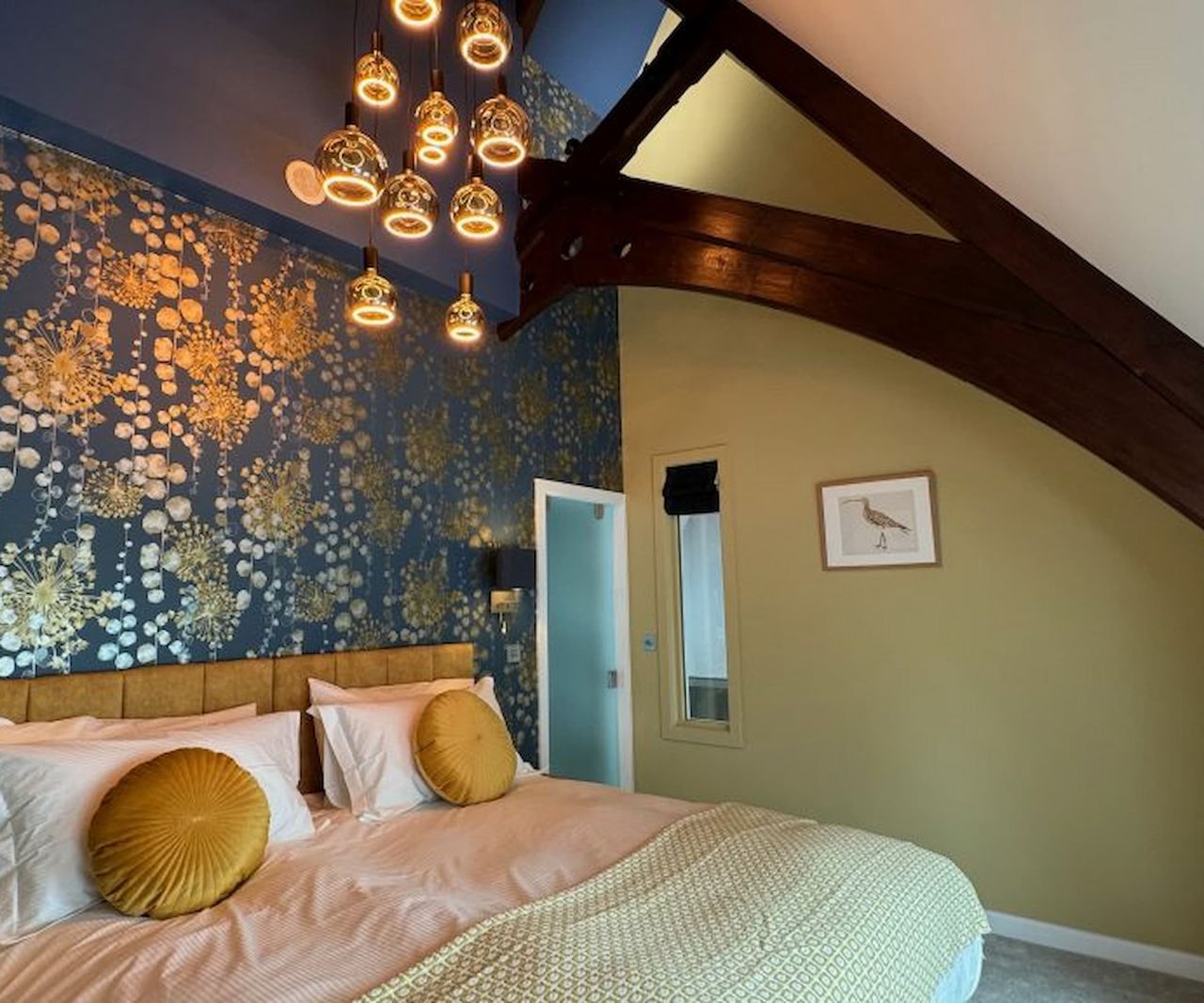 A bedroom with exposed timber beam and flower pattern wallpaper