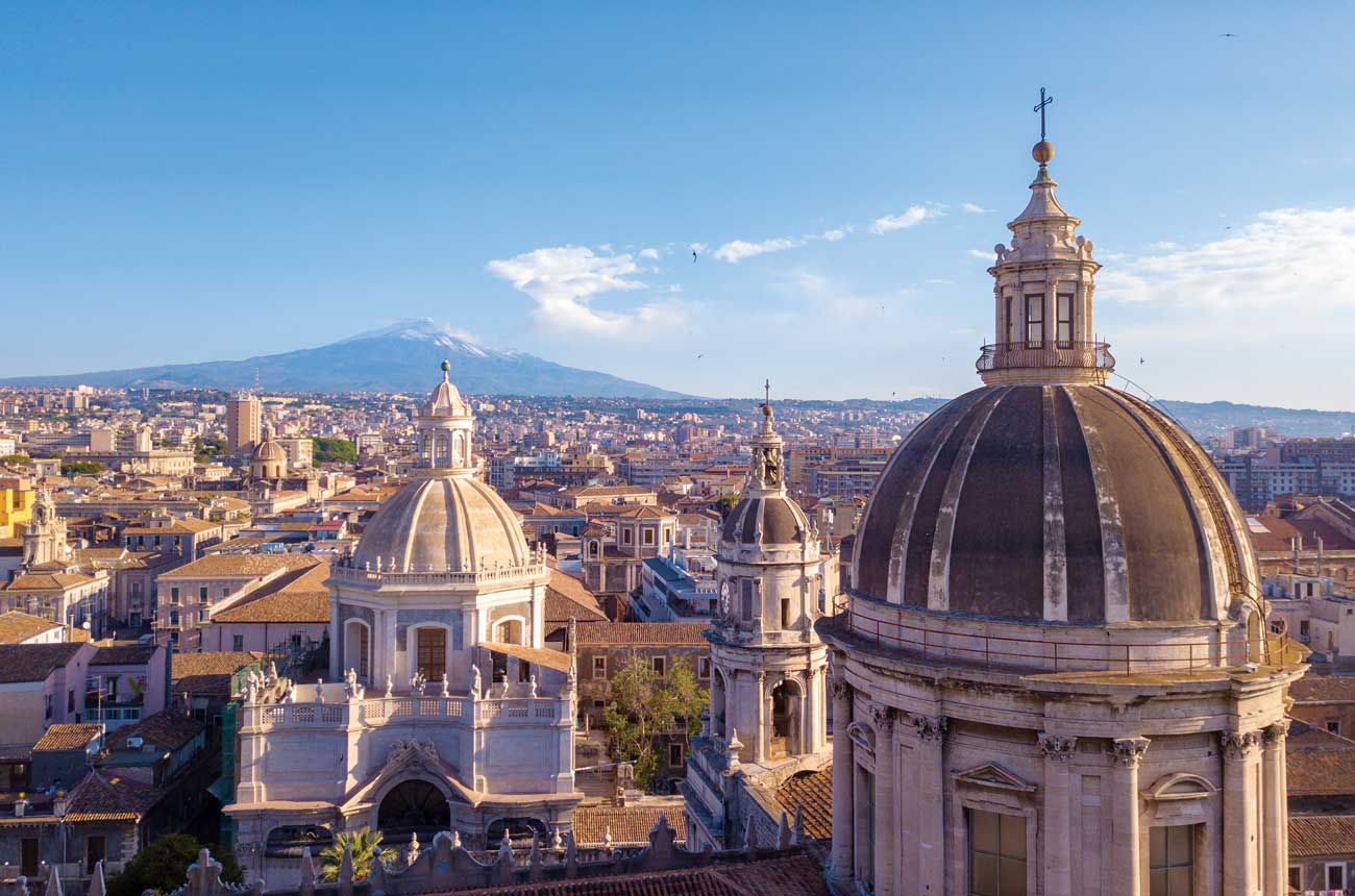 Domes around Sant'Agata cathedral in central Catania with Mount Etna in the background to the north.