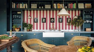 Blue cabinets and drawers, wicker chairs, red and white stripe walls