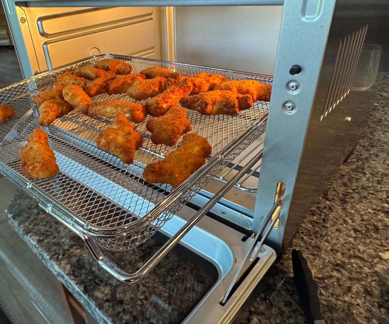 Chicken nuggets arranged on a wire mesh tray in the Typhur Sync Air Fryer Oven