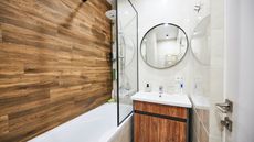 small bathroom vanity and shower with wooden shower wall