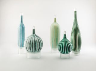 Five vases of different heights with a striped motif in light green